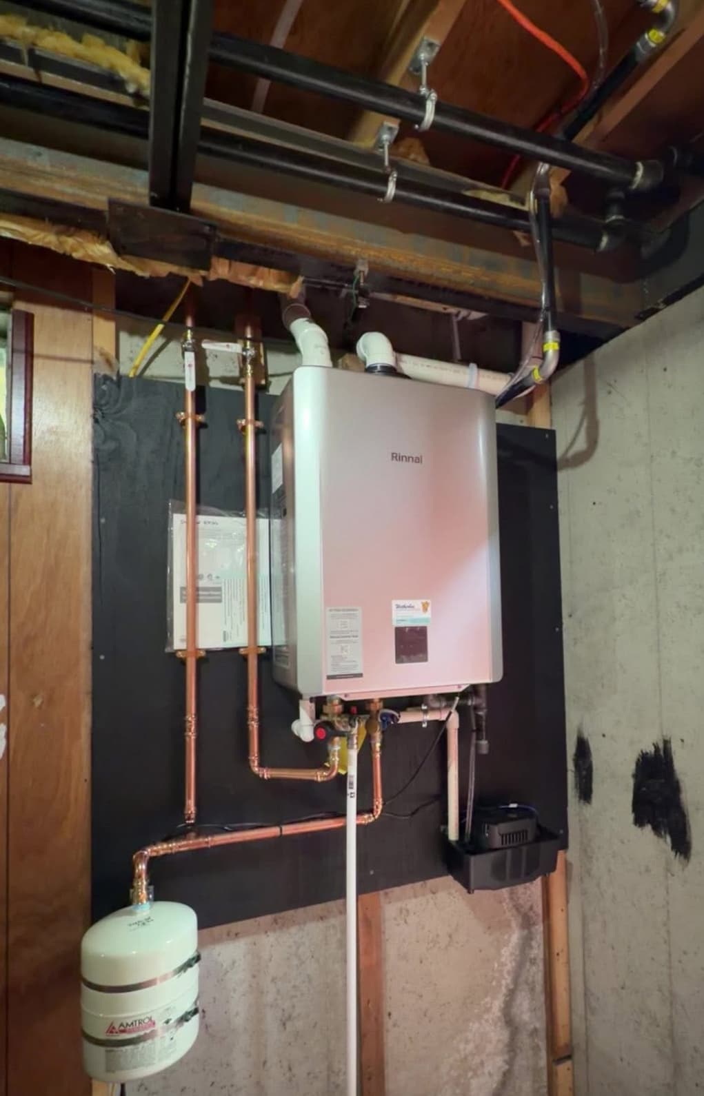 Wall-mounted Rinnai tankless water heater replacement with copper supply lines and condensate trap
