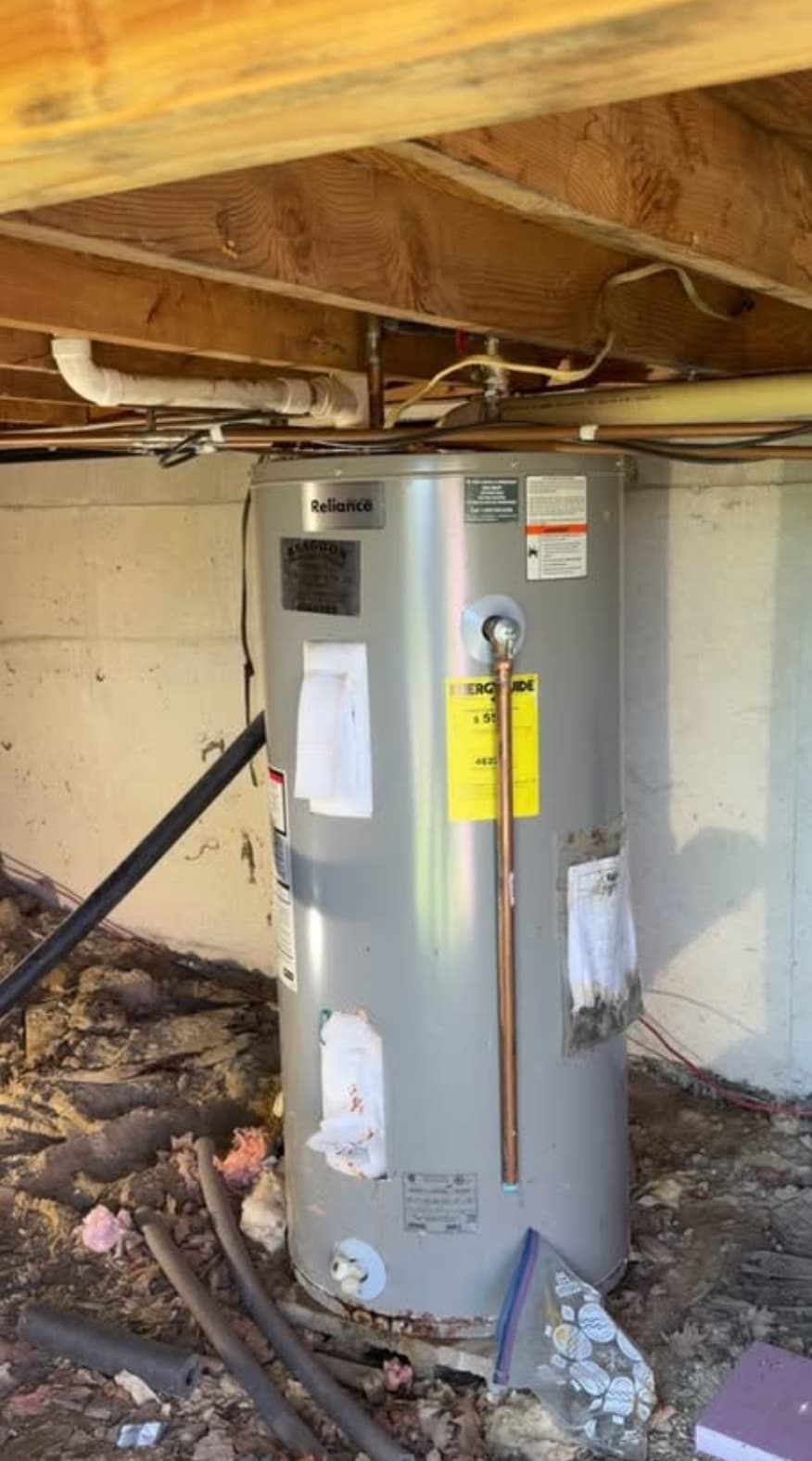 Aging Reliance tank water heater in a basement crawl space — typical candidate for replacement in older Leawood homes